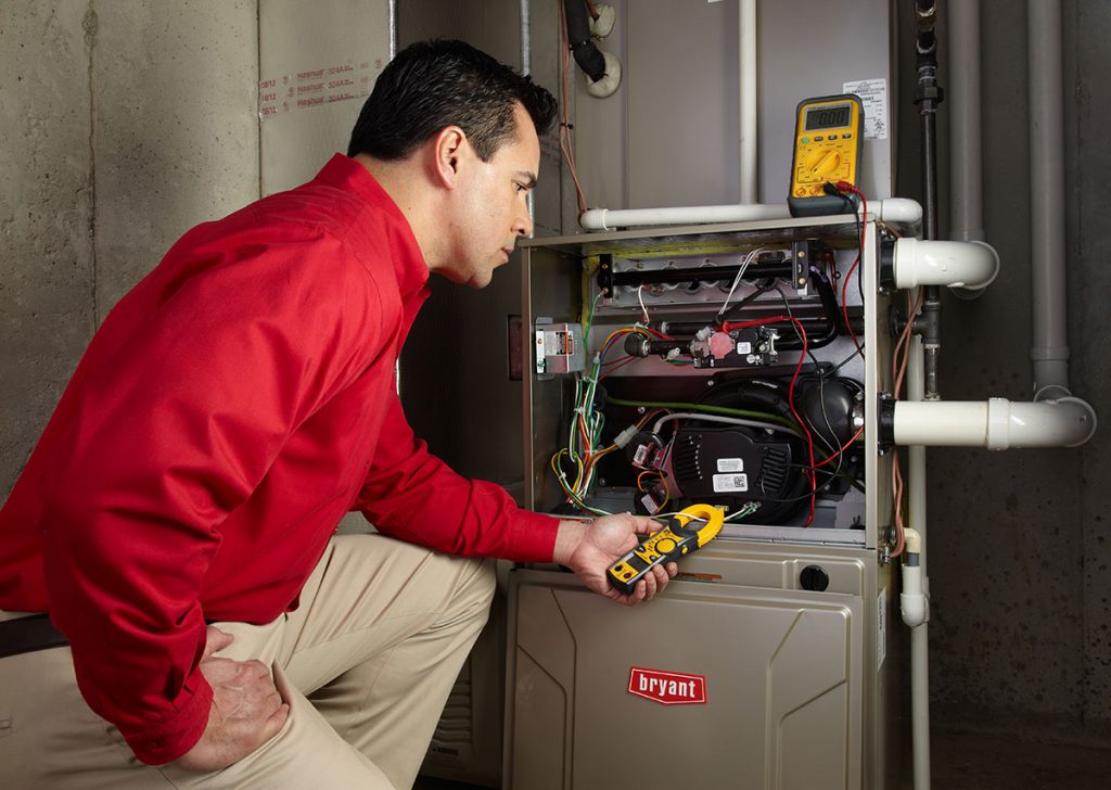 Heating and air conditioning technician servicing an indoor furnace in Littleton, CO