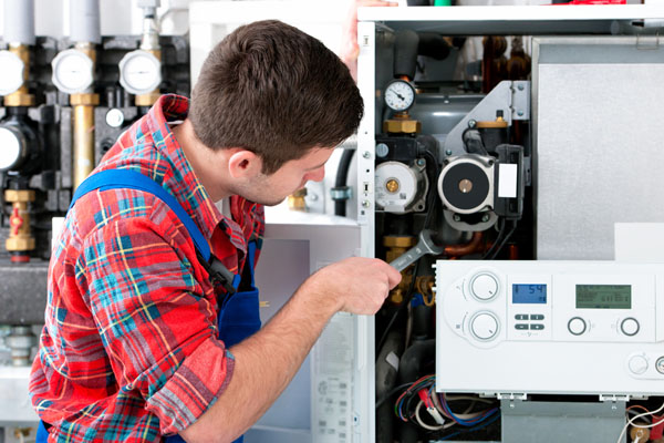 HVAC technician inspecting an indoor heating system in Littleton, CO