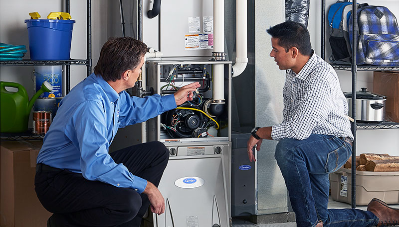 HVAC technician evaluating a furnace for repair or replacement in Littleton