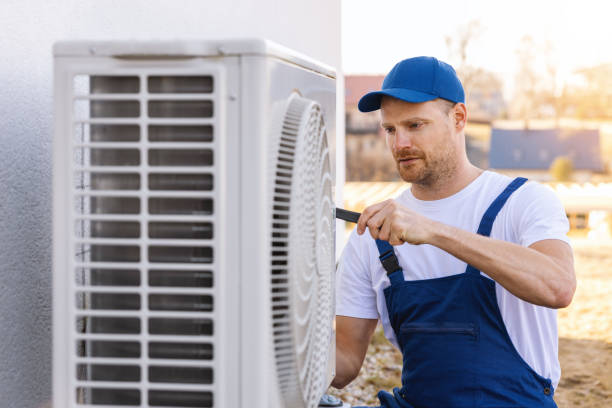 HVAC technician servicing an outdoor air conditioning unit in Littleton