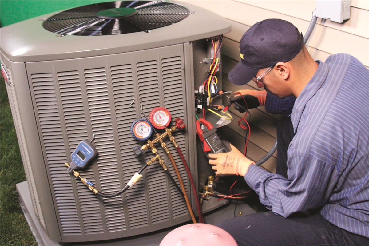 HVAC technician testing an outdoor air conditioning unit in Littleton