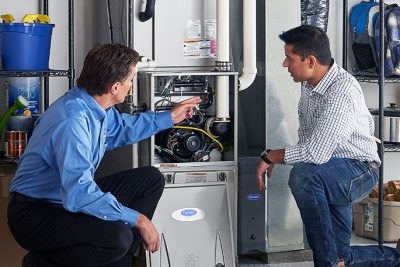 HVAC technician explaining furnace repair and maintenance to a homeowner in Littleton, CO