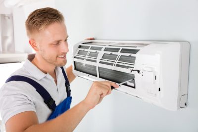HVAC technician cleaning and repairing a ductless mini split AC in Littleton, CO